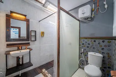 a bathroom with a toilet and a sink and a shower at Senyum Bali Inn 1BR Sanur in Sanur