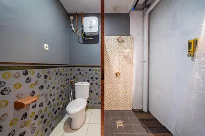a bathroom with a toilet and a shower at Senyum Bali Inn 1BR Sanur in Sanur