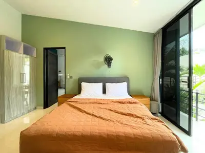 a bedroom with a large bed with an orange bedspread at Villa EM Umalas by Satran Villa in Kerobokan