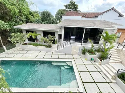 a house with a swimming pool in front of a house at Villa EM Umalas by Satran Villa in Kerobokan