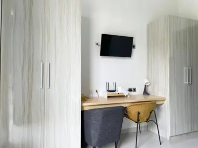 a desk in a room with a tv on a wall at Villa EM Umalas by Satran Villa in Kerobokan