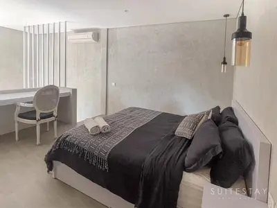 a bedroom with a bed with a desk and a chair at Modern Duplex With Stylish Design in Canggu