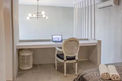 a bedroom with a desk and a chair with a laptop at Modern Duplex With Stylish Design in Canggu