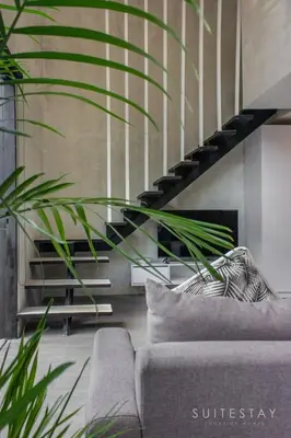 a living room with a couch and a staircase at Modern Duplex With Stylish Design in Canggu