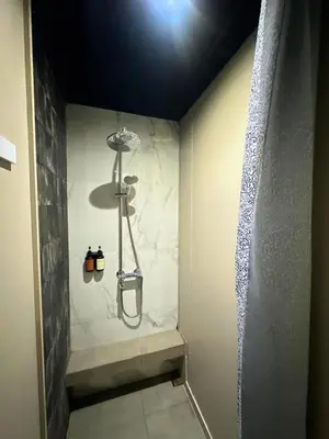 a bathroom with a shower with a shower curtain at Althia Private Capsule Quarters in Badung