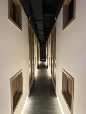 an empty hallway of a building with wooden doors at Althia Private Capsule Quarters in Badung