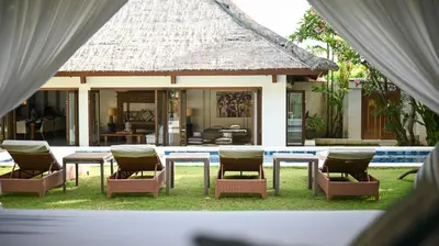 a group of chairs and tables in front of a house at Casa Evaliza by Elite Havens in Seminyak