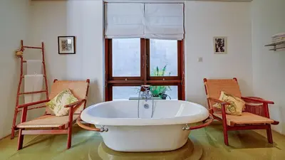 a large bath tub in a room with two chairs at Casa Evaliza by Elite Havens in Seminyak