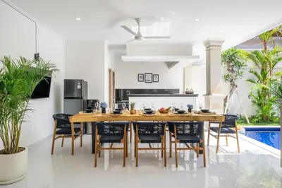 a kitchen and dining room with a wooden table and chairs at Semera - Luxury Villa with a Spacious Pool in the Prime Location in Kerobokan