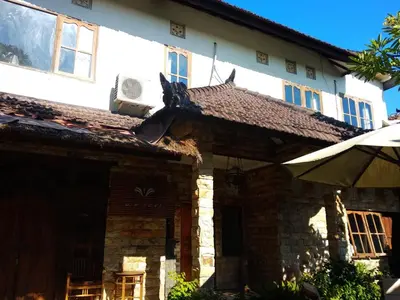 an old house with a roof on the side of it at Bcoss Stay in Jimbaran