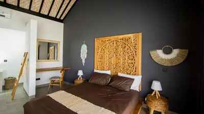 a bedroom with a bed with a wooden headboard at Villa La madrina in Kerobokan