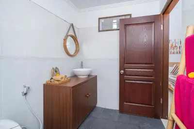 a bathroom with a sink and a wooden door at Bali Huis Villa in Seminyak