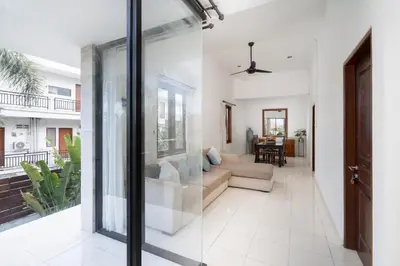 a living room with a couch and a glass door at Bali Huis Villa in Seminyak