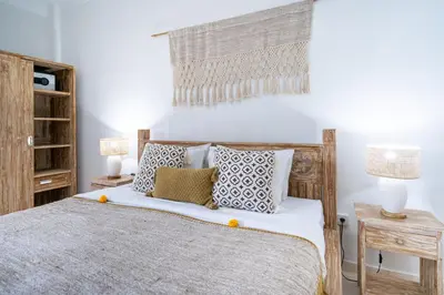 a bedroom with a wooden bed with pillows at Bali Huis Villa in Seminyak