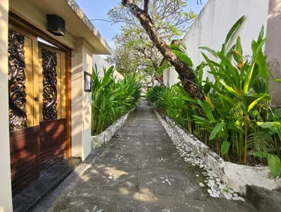 a walkway leading to a house with plants at Privat Pool Villa at Kuta in Kuta