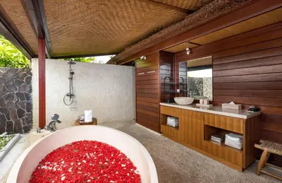a bathroom with a tub filled with lots of redmsg at Palm Merah Villa in Umalas