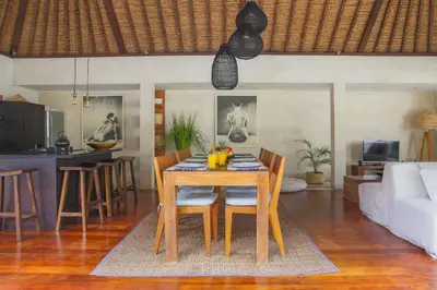 a dining room and living room with a table and chairs at Villa Charlie Seminyak in Badung