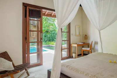 a bedroom with a bed and a sliding glass door at Villa Charlie Seminyak in Badung