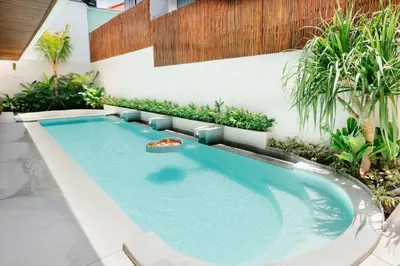 a swimming pool in the middle of a garden at Luxury Villa Noah in Kuta