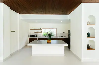 a kitchen with white walls and a wooden ceiling at Luxury Villa Noah in Kuta