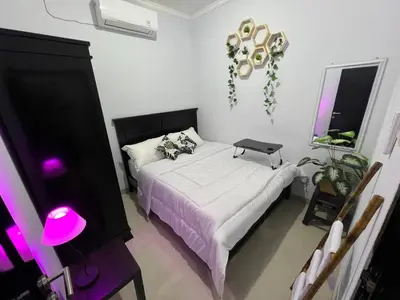 a bedroom with a bed with a laptop on it at Chandra's House in Pesanggaran