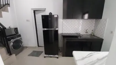 a kitchen with a refrigerator and a washing machine at Chandra's House in Pesanggaran