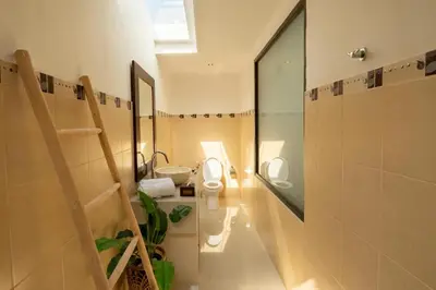 a bathroom with a toilet and a sink and a mirror at Gemstones Villa in Seminyak