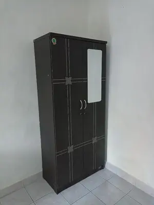 a black cabinet with a door in a room at Tokomang Homestay in Legian