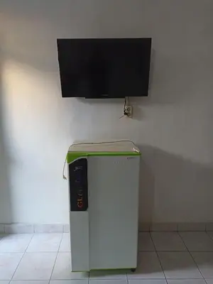a small refrigerator with a flat screen tv on the wall at Tokomang Homestay in Legian