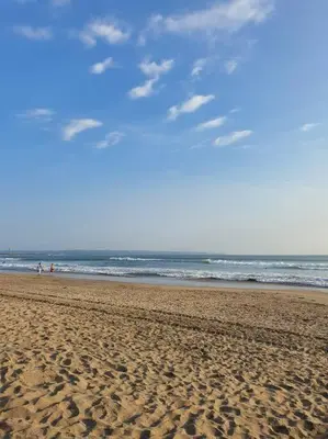 a beach with people walking on the sand and the ocean at C&C Apartment Jayakarta Residence Legian Bali A 6319 in Seminyak