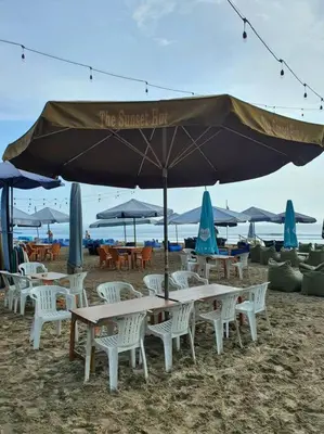 a group of tables and chairs under an umbrella on the beach at C&C Apartment Jayakarta Residence Legian Bali A 6319 in Seminyak