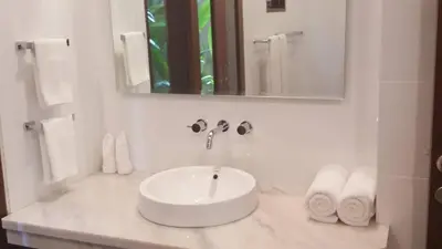 a white bathroom with a sink and a mirror at Villa Green Mango 2 Seminyak Bali in Seminyak