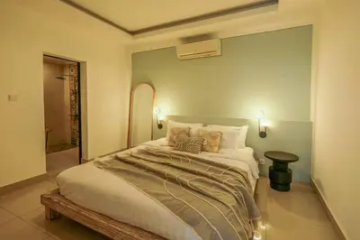 a bedroom with a large bed with two pillows at Casa De Beji Seminyak in Seminyak