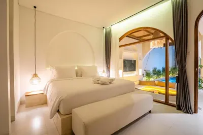a bedroom with a bed and a large window at La Feliz Villa Seminyak in Seminyak