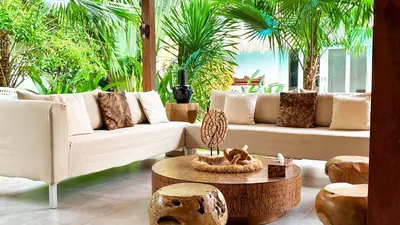 a living room with couches and a table and trees at Villa Sukacita - Family Friendly 4BR Seminyak Eat Street 900m Walk To Beach in Seminyak