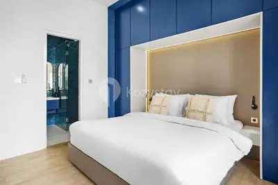 a bedroom with a large white bed with blue walls at Calisee Villa by Kozystay - Denpasar in Seminyak
