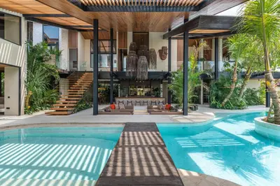 an exterior view of a house with a swimming pool at Villa Baratega - Dreamy Urban Tropical 6BR Villa for Large Group in Kerobokan