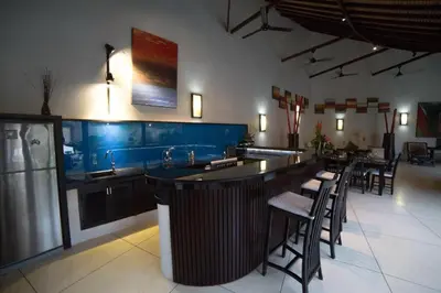 a bar in a restaurant with a counter and chairs at Timang Villa, Jimbaran-Bali in Jimbaran