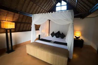 a bedroom with a bed with a canopy and a window at Timang Villa, Jimbaran-Bali in Jimbaran