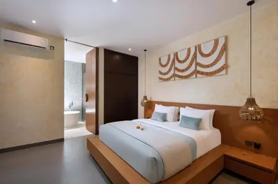a bedroom with a large bed and a bathroom at Oza Villa Canggu Managed by LEAD in Canggu