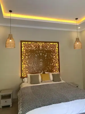 a bedroom with a bed with a large painting on the wall at Tranquil Family Villa Retreat in Umalas in Kerobokan
