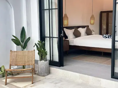 a bedroom with a bed and a chair at Private Pool Seminyak Central 2BR Villa in Seminyak