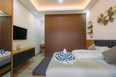 a hotel room with a bed and a tv at The Lavana Sahadewa Villa Kuta Sunset in Legian