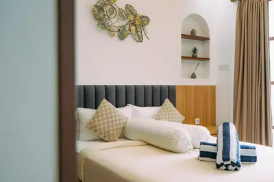 a hotel room with a bed with a clock on the wall at The Lavana Sahadewa Villa Kuta Sunset in Legian