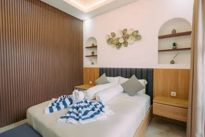 a bedroom with two beds with pillows on them at The Lavana Sahadewa Villa Kuta Sunset in Legian