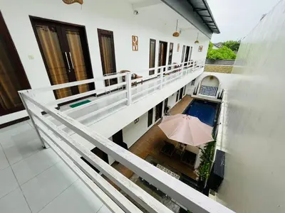 an external view of a balcony with an umbrella at Double D Guesthouse and Villa in Kerobokan