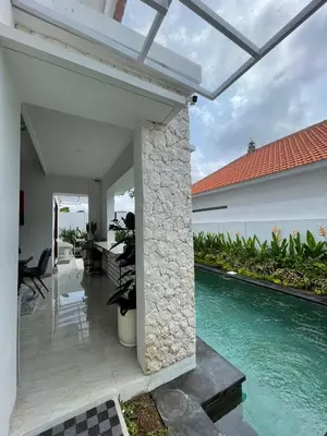 a patio with a swimming pool next to a house at New 2BR Villa Private Pool Near Seminyak in Kerobokan