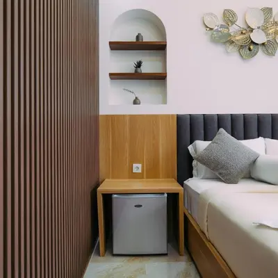a bedroom with a bed and a nightstand next to a bed at The Lavana Nakula Villa Kuta Sunset in Kuta