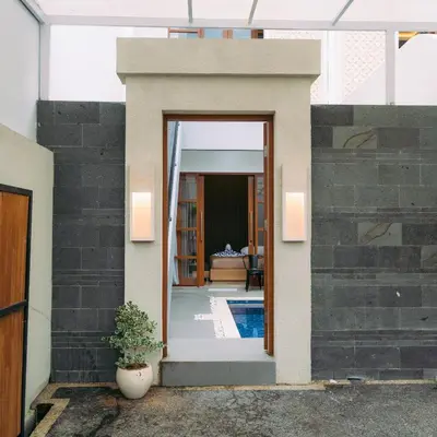 a house with a glass door leading to a pool at The Lavana Nakula Villa Kuta Sunset in Kuta