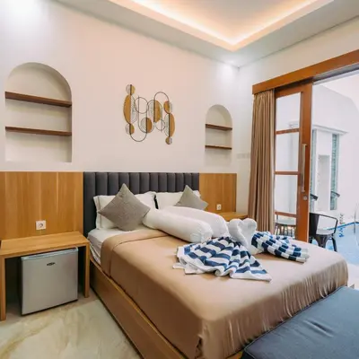 a bedroom with two beds and a window at The Lavana Nakula Villa Kuta Sunset in Kuta